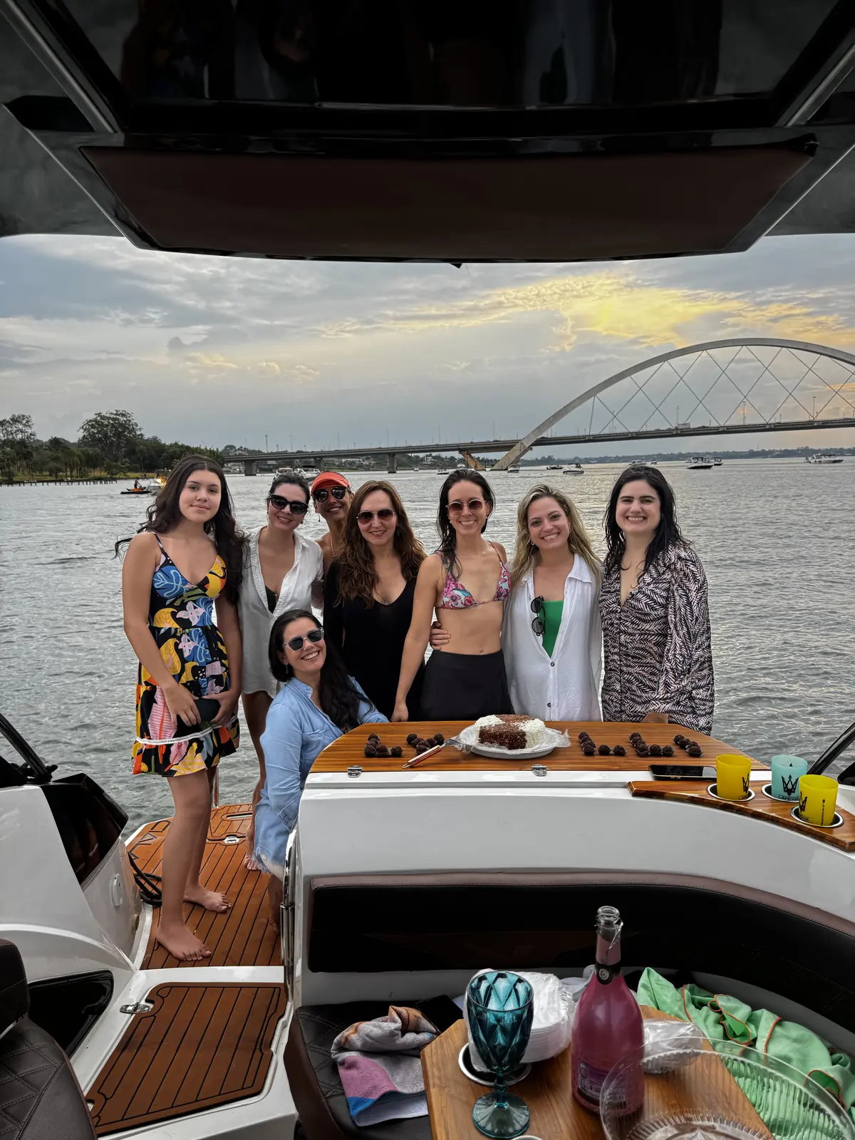 Aniversário comemorado a bordo da lancha no Lago Paranoá, com bolo e a Ponte JK ao fundo