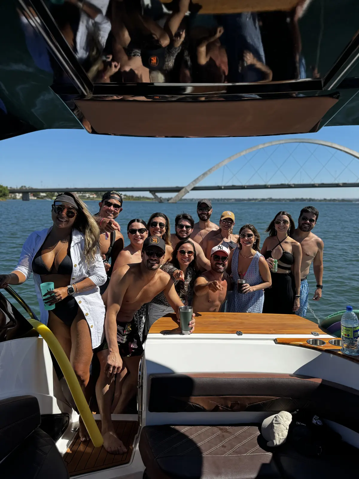 Grupo de amigos reunido na lancha com a Ponte JK ao fundo, Brasília